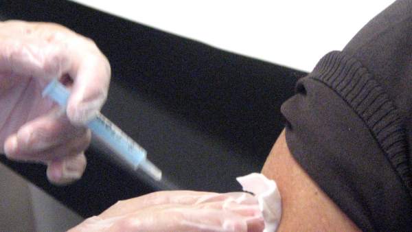 Un profesional sanitario suministra una vacuna a un paciente. Un profesional sanitario suministra una vacuna a un paciente.